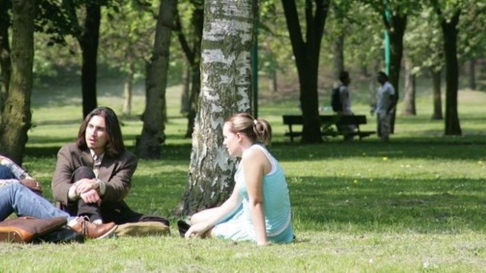 Three students sat in Peel Park, Salford