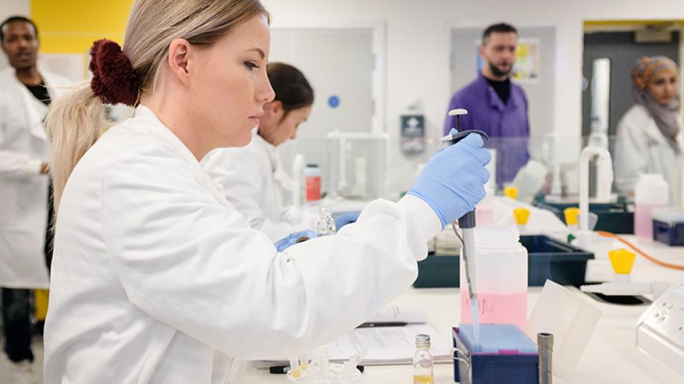 Chemistry student using a pipette in a laboratory