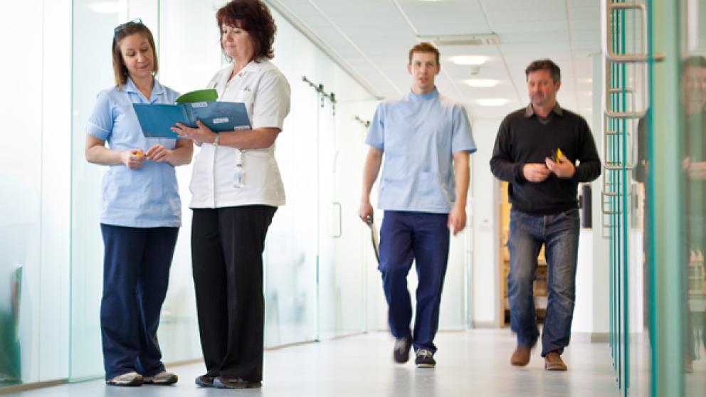 Members of staff walking inside the Podiatry Clinic, University of Salford