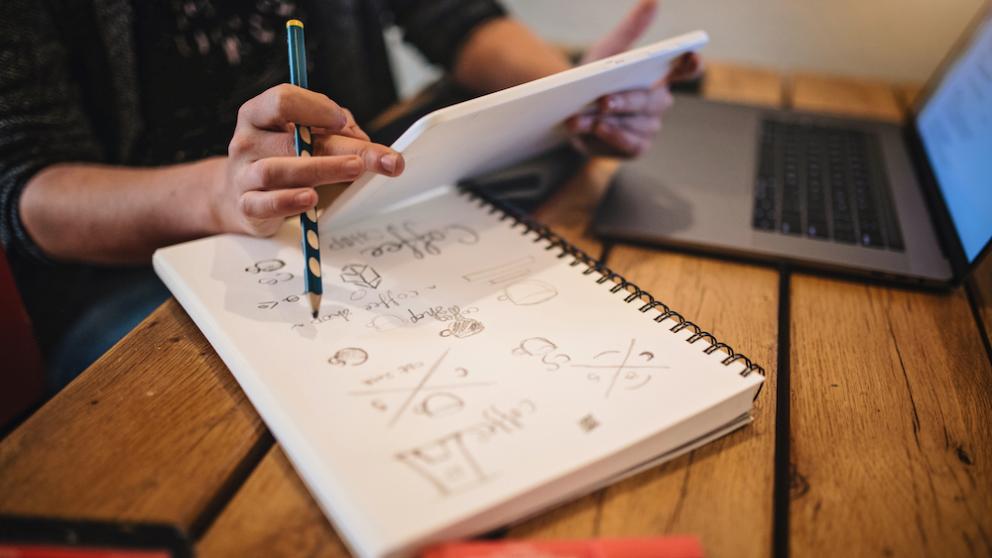 Person making notes on writing pad