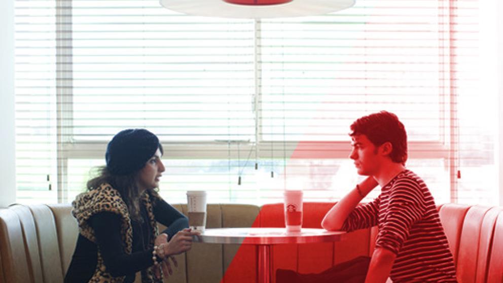 Students talking over coffee sat together in a booth