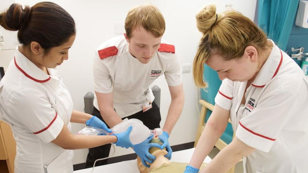 Student nurses around a mannequin 