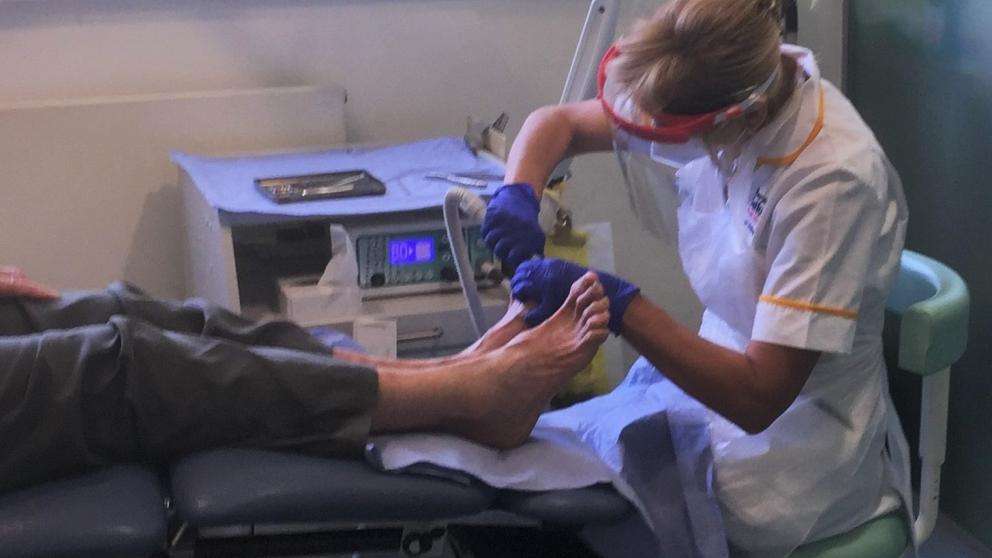 Healthcare professional performing a foot care treatment