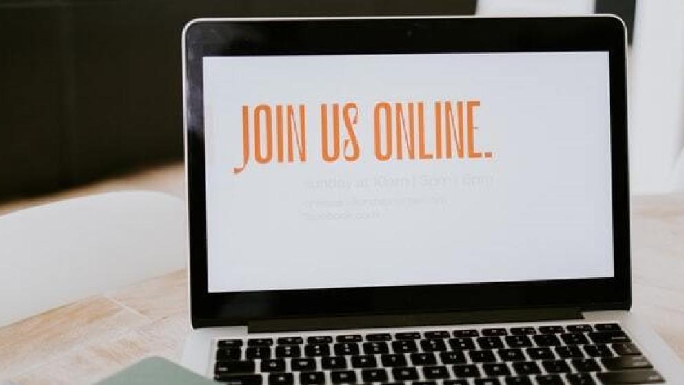Laptop screen which reads 'join us online' in orange text. 