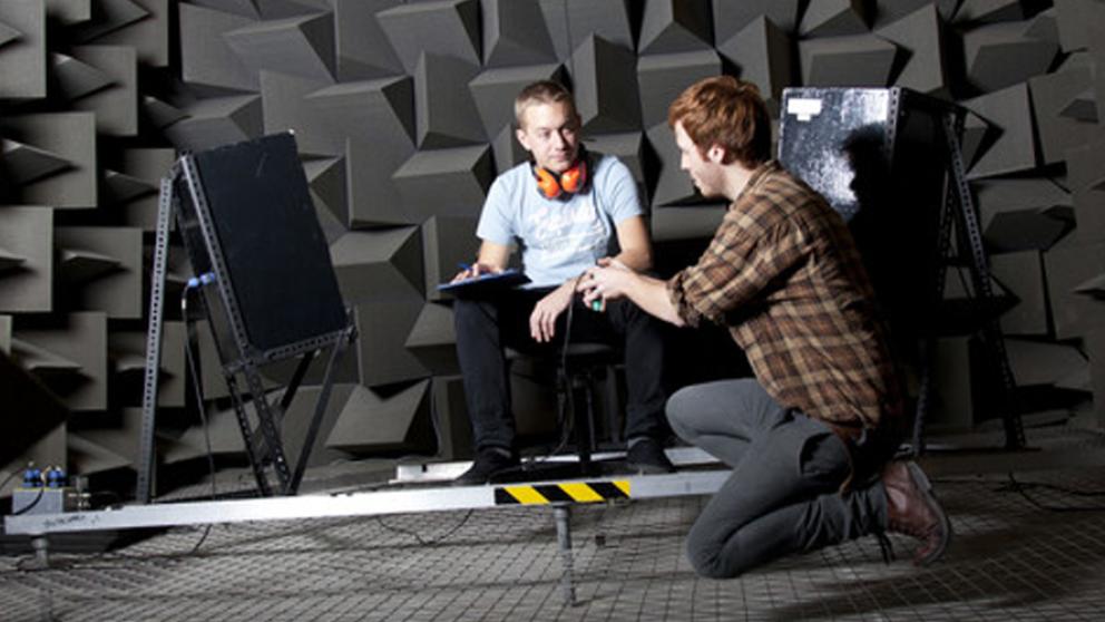 Two students working on equipment in the anechoic chamber, Newton Building, University of Salford