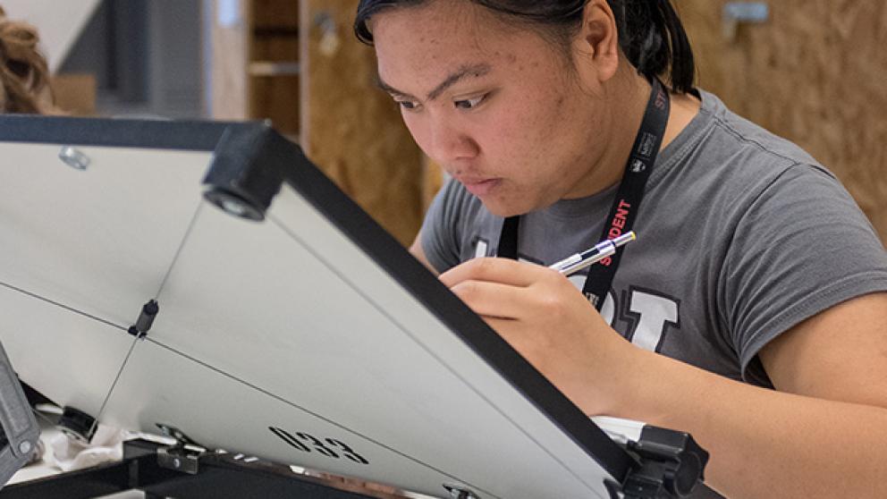 Student using an architects drawing board