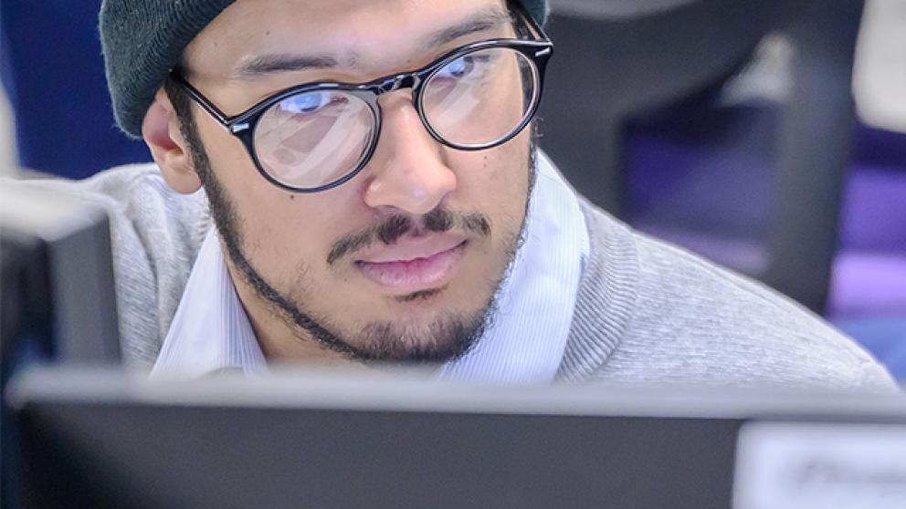 Computing student looking at a monitor screen