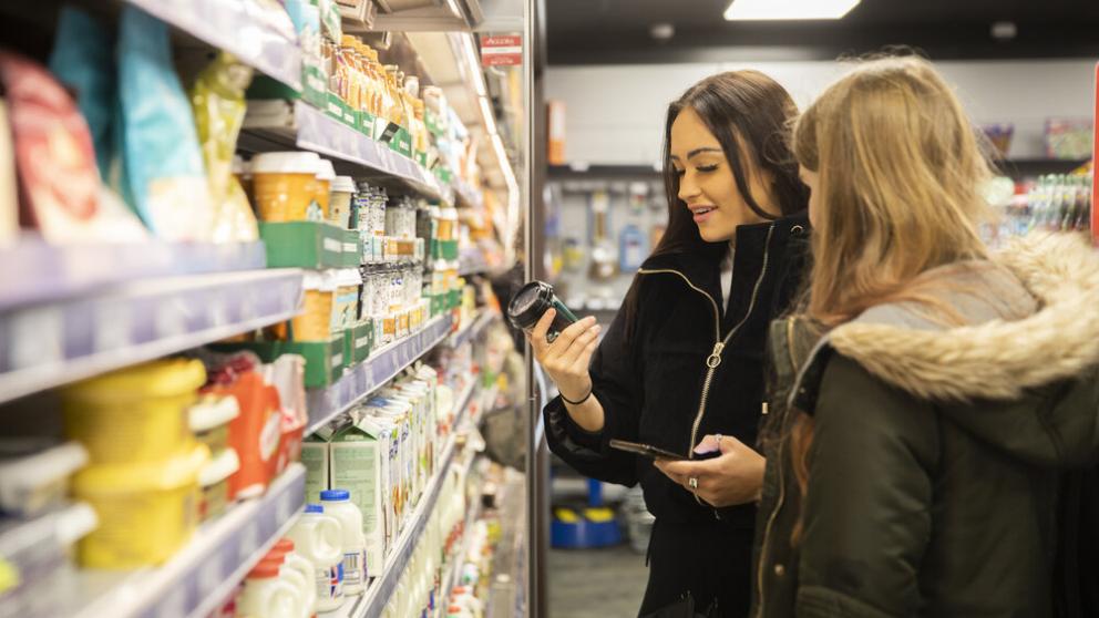 Two students browsing the aisles in the student store on Peel Park campus