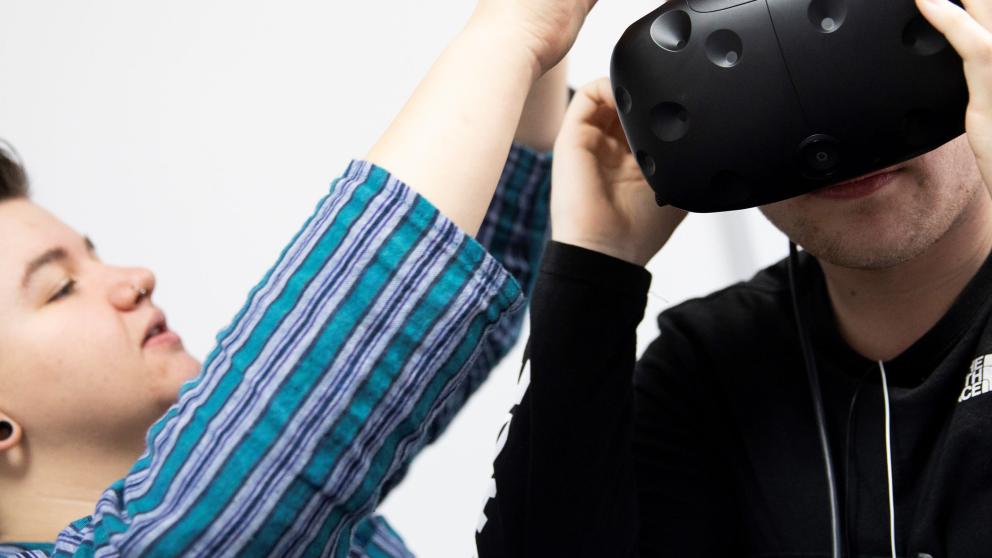 Paige Metcalfe helping a colleague with their virtual reality headset