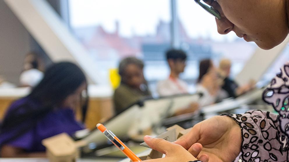 Architecture student using a paper trimmer in a classroom setting