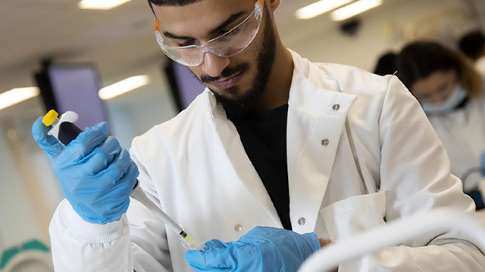 Student carrying out experiment in biomedical science lab