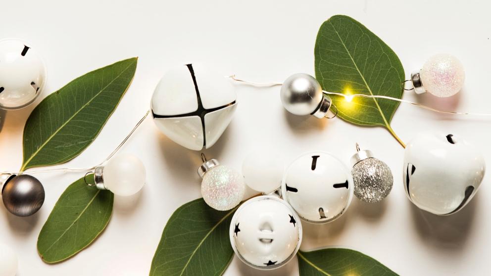 Festive arrangement of Christmas decorations including bells, baubles and green leaves