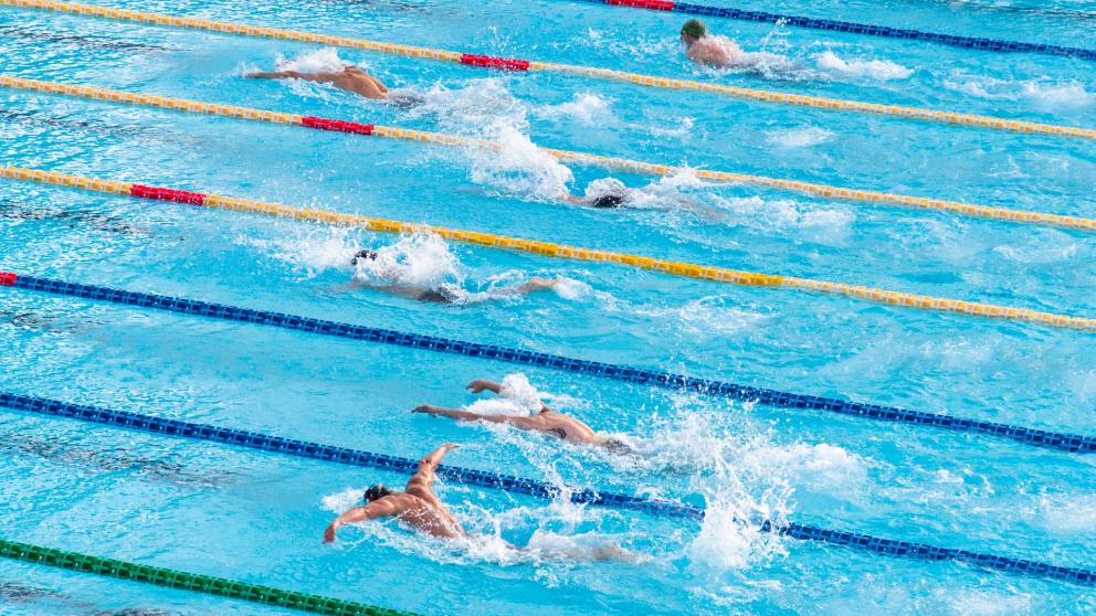 Six swimmers competing in a breaststroke race