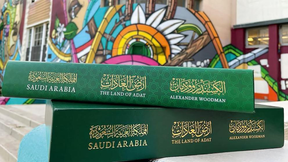 an image showing the life of adat book in front of a colourful wall