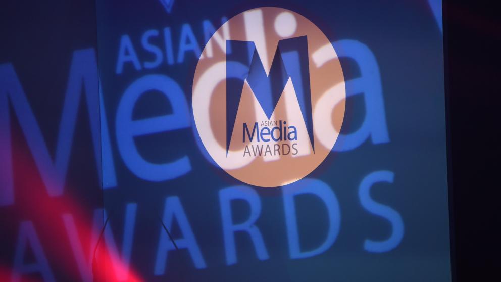 Asian Media Awards logo on a spotlight