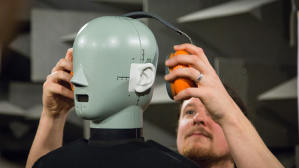 Man testing headphones on a robot