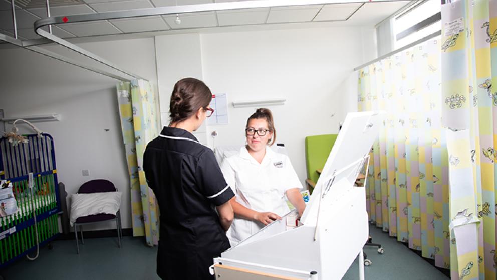 Female student engaging with female lecturer in the University of Salford medical suite.