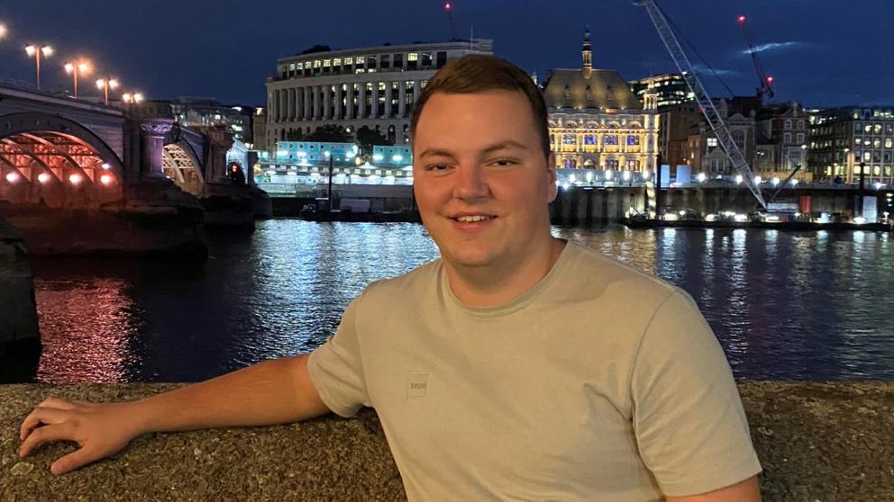 a man posing in front of bridge