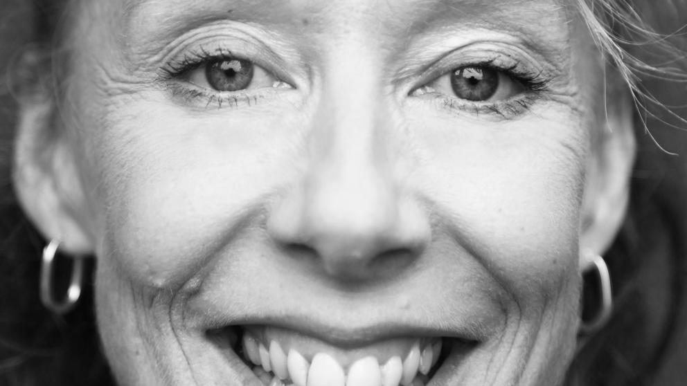 A black and white portrait of a woman smiling