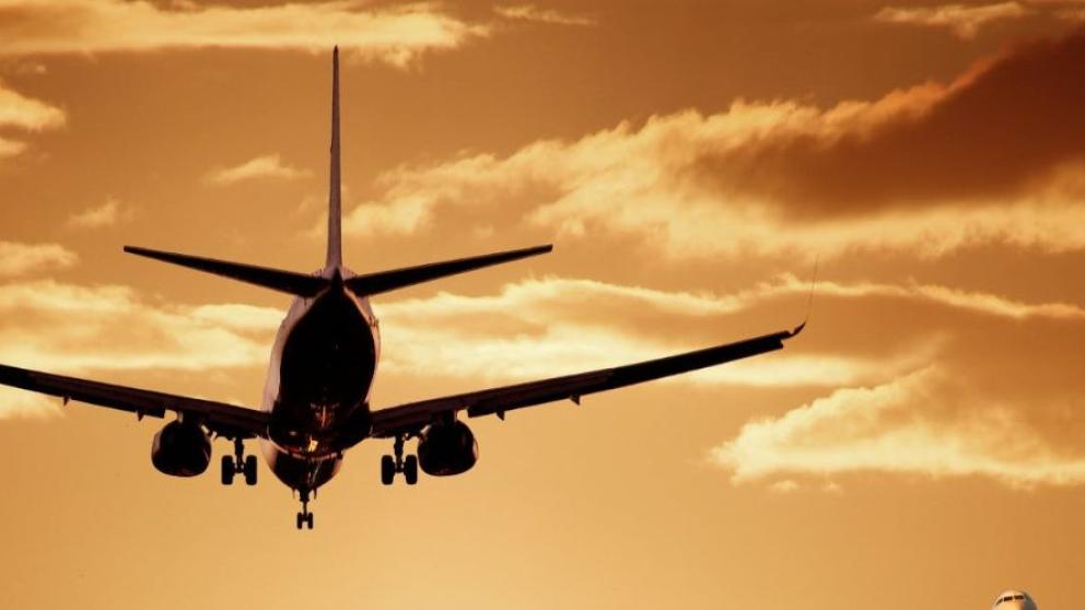 Plane flying at sunset