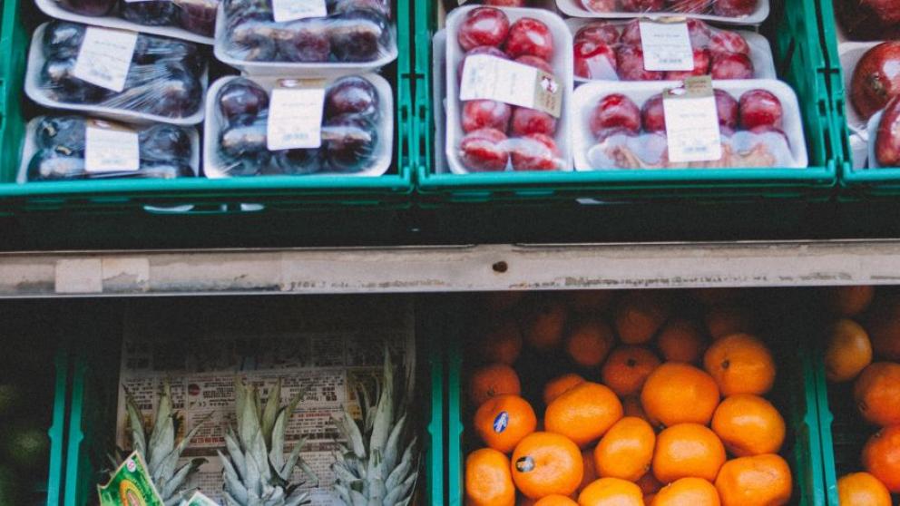 Eight crates of different fruits on a market stall