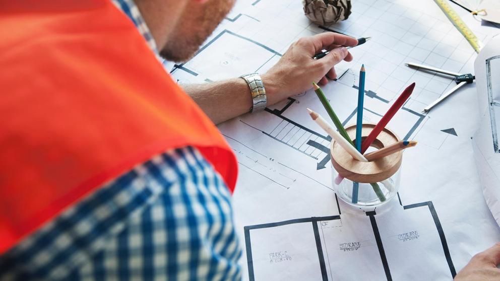 Apprentice reviewing multiple floor plans