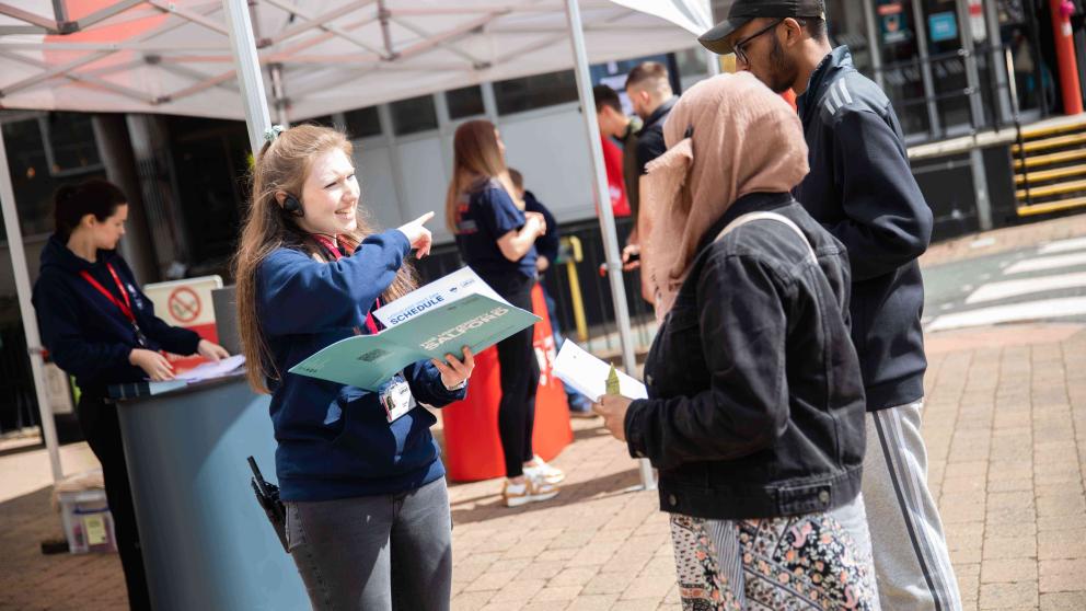Visitors receiving information booklet on open day 