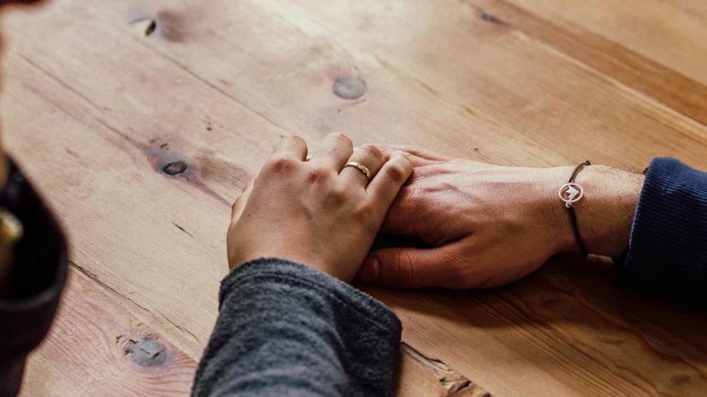 Supportive hand on wooden table