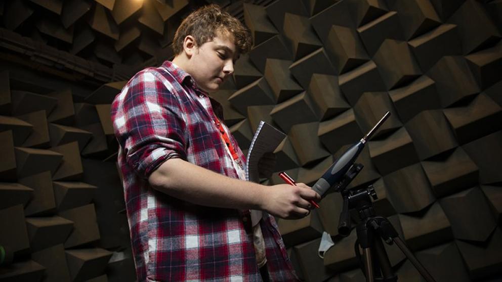 Student working on equipment in the anechoic chamber, Newton Building, University of Salford