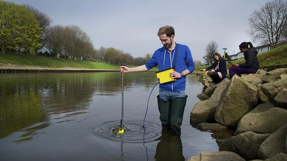 Geography students on a field trip in a river