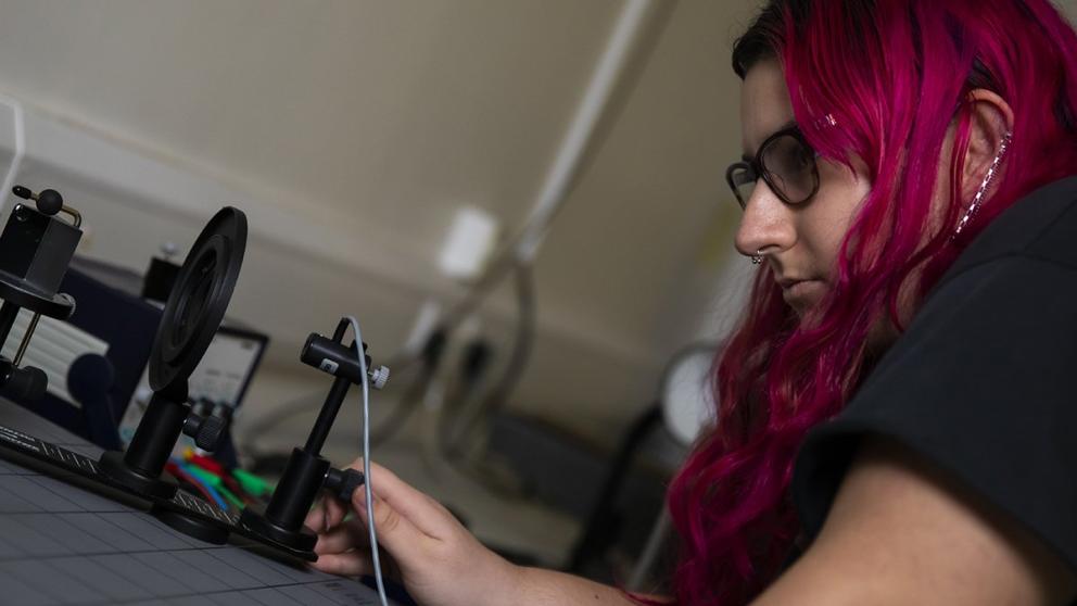 Student conducting physics experiment with equipment