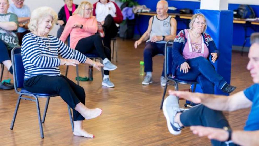 Group of elderly people doing seated exercise