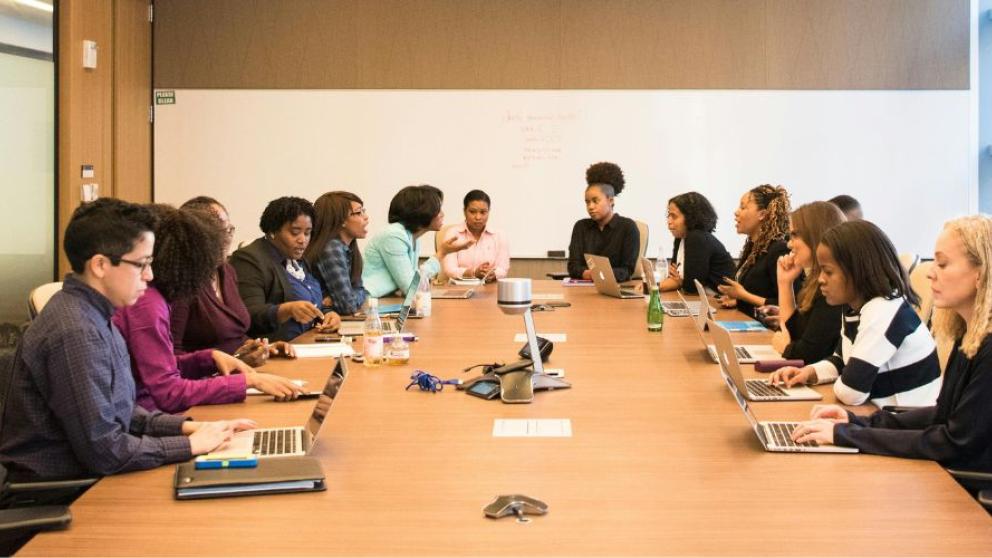 14 people sat around a table at a board meeting