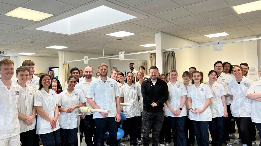 Alex Brooker standing with a large group of university students