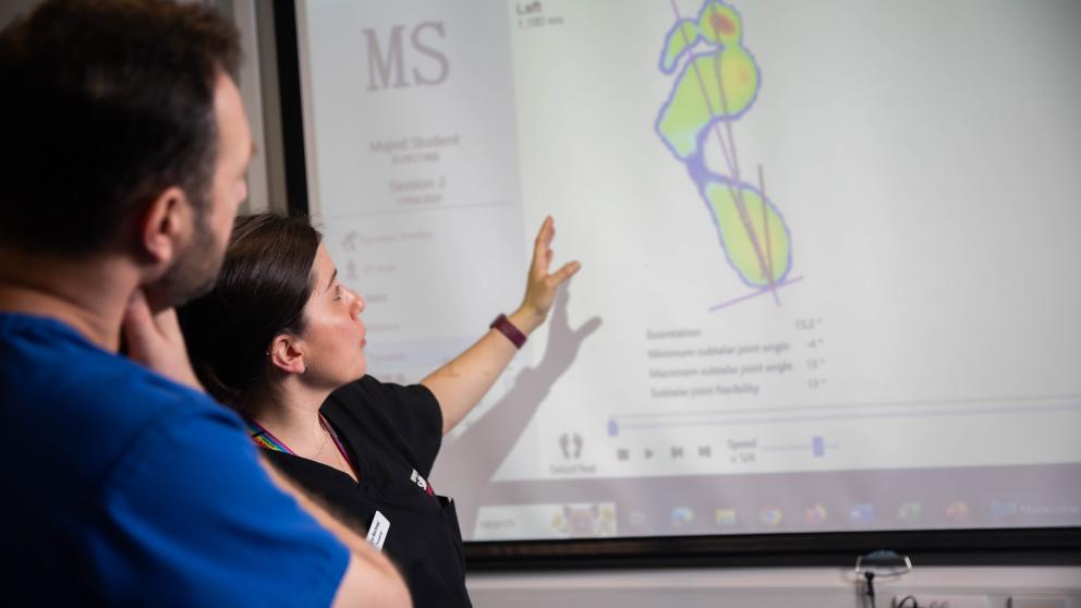 Podiatry tutor and student reviewing information from conducting musculoskeletal tests using a force plate