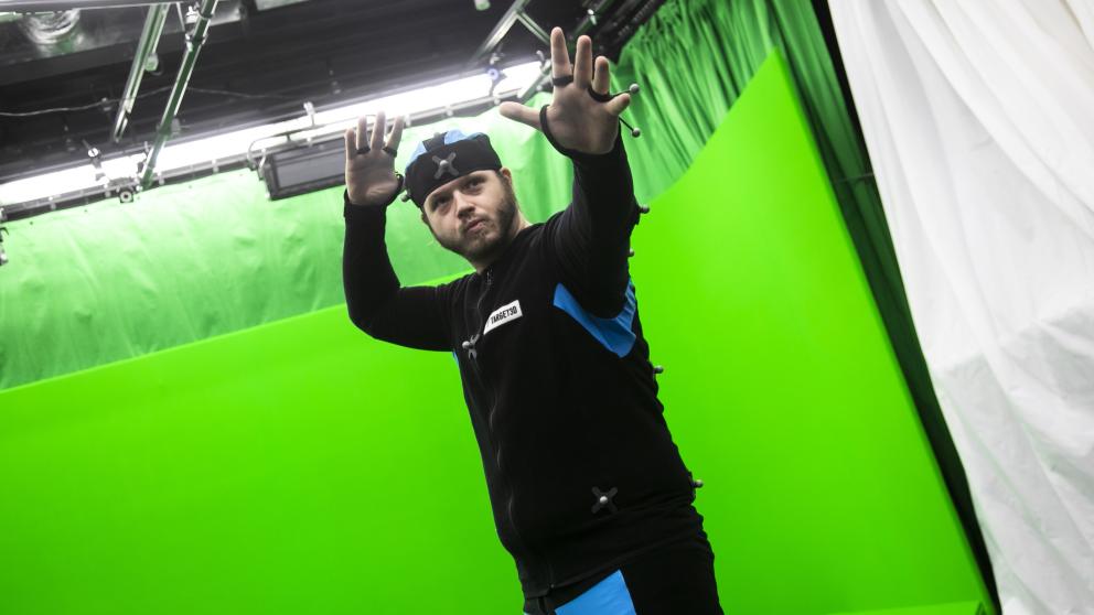 Student using motion capture technology in front of a green screen 