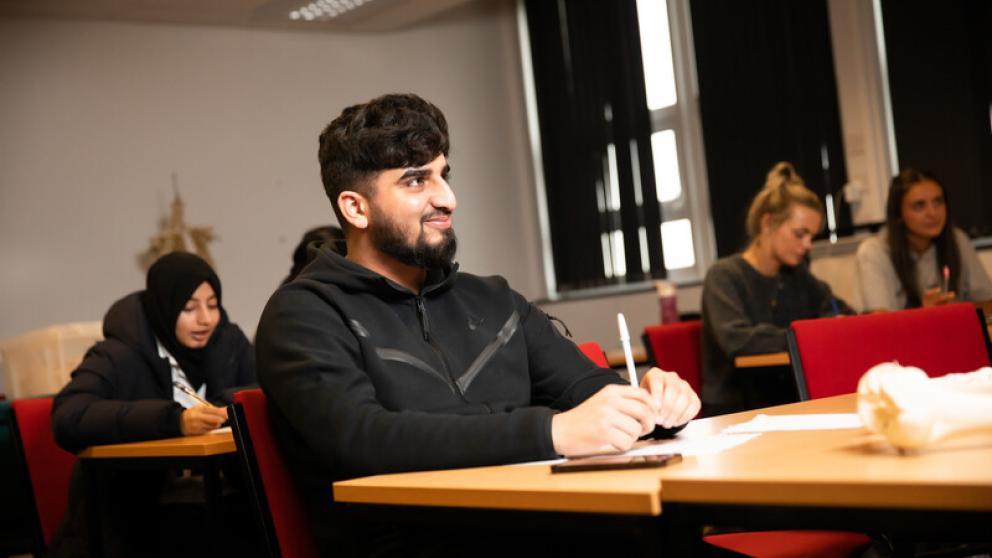 Students sat in a classroom listening to tutor
