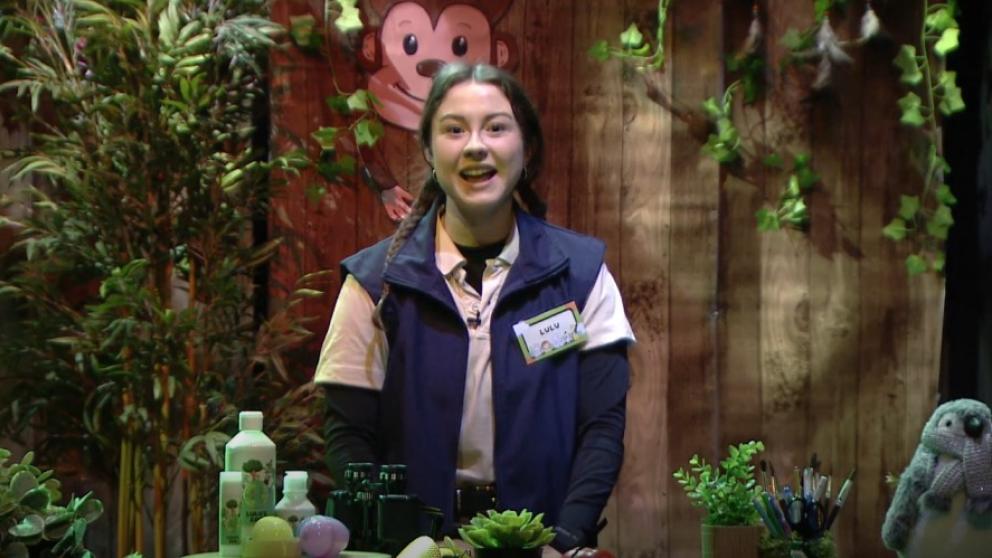 Sarah Baker on a television set that resembles a zoo