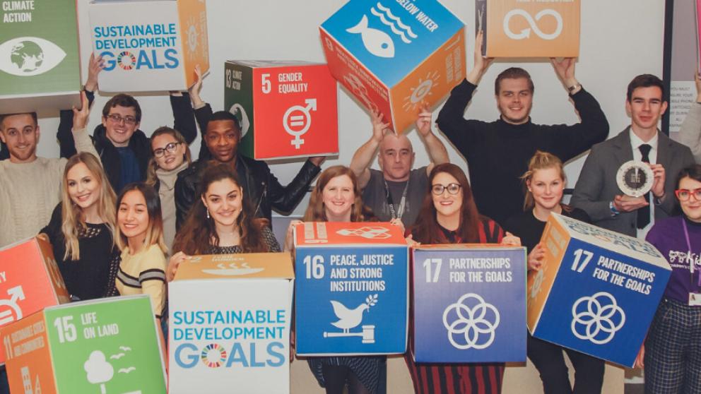 Students and staff holding Sustainable Development Goals cubes