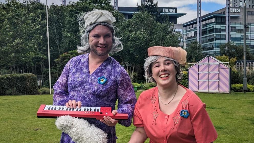 Brightly dressed figures at Mediacity interact for Carers Week