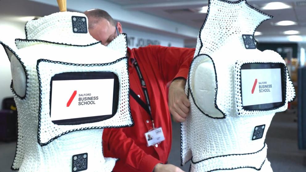 Two dresses with ipads placed within them reading Salford Business School