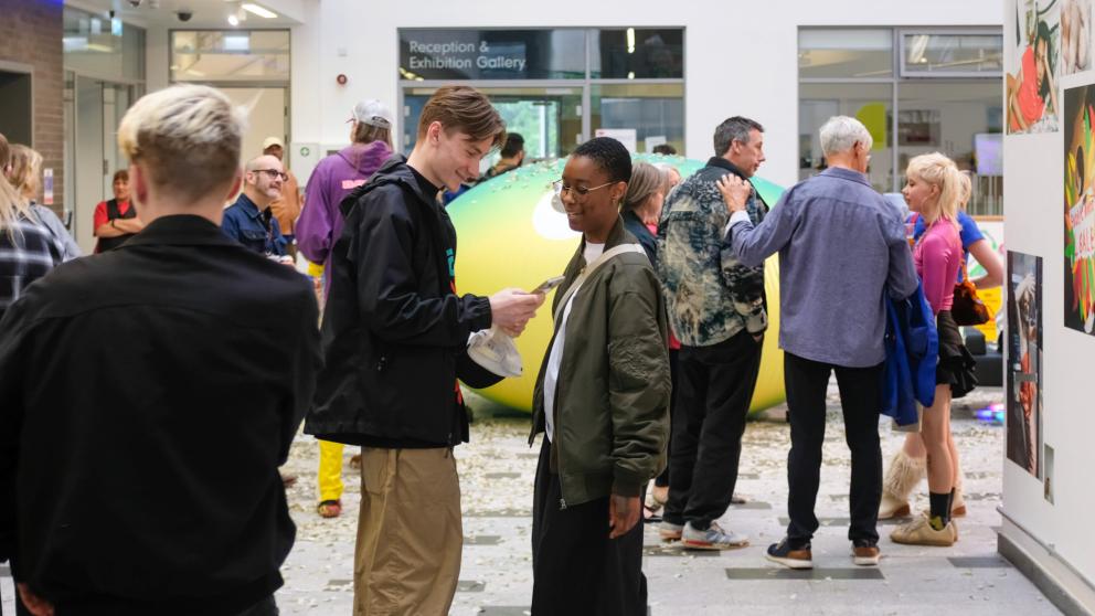 People viewing art and chatting at the University of Salford Degree Show 2022