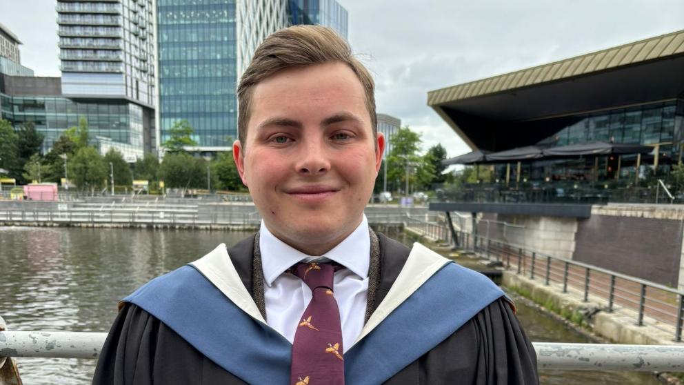 Joe Williams in graduation robes outside The Lowry