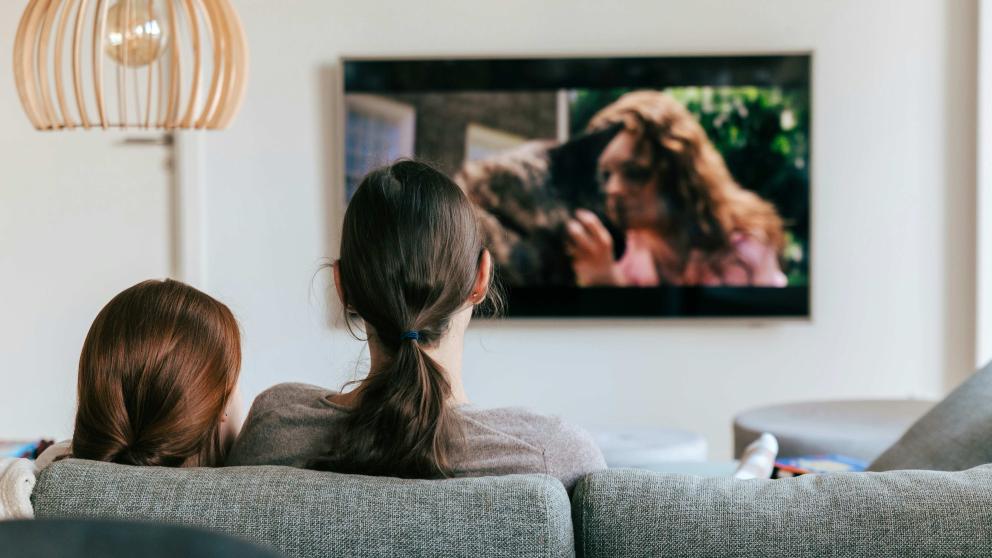 Family watching a wall mounted television set