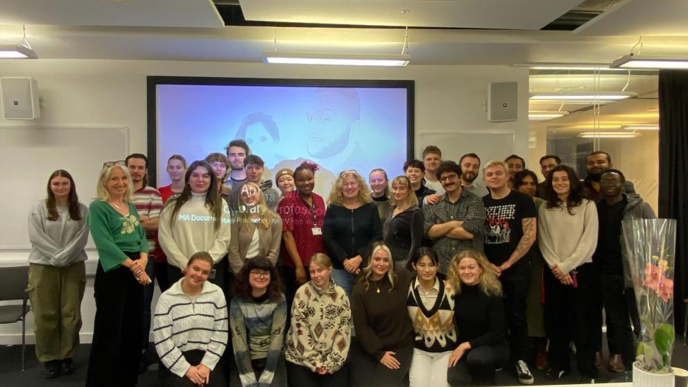 Anna Hall stands in the middle surrounded by other Salford students at our MediaCity campus