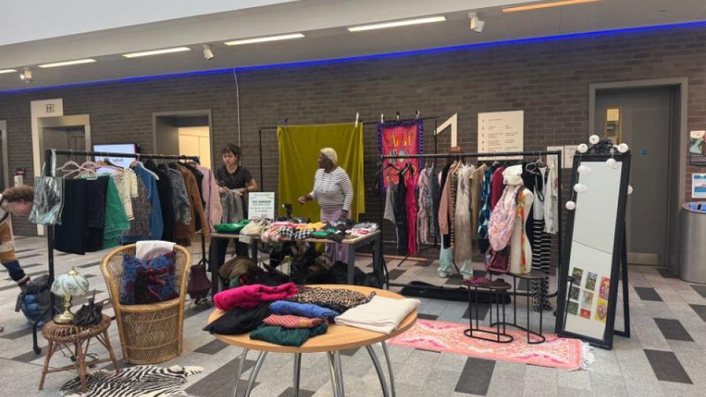 people are looking at clothes on rails and table 