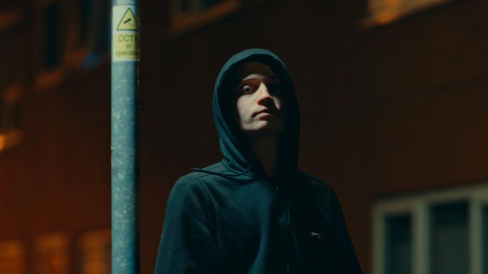 A character stands by a lamp post in the film Trapped!