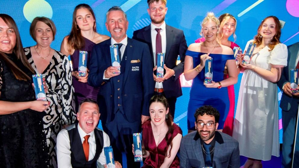 All the award winners pictured holding their trophies onstage at the ceremony 