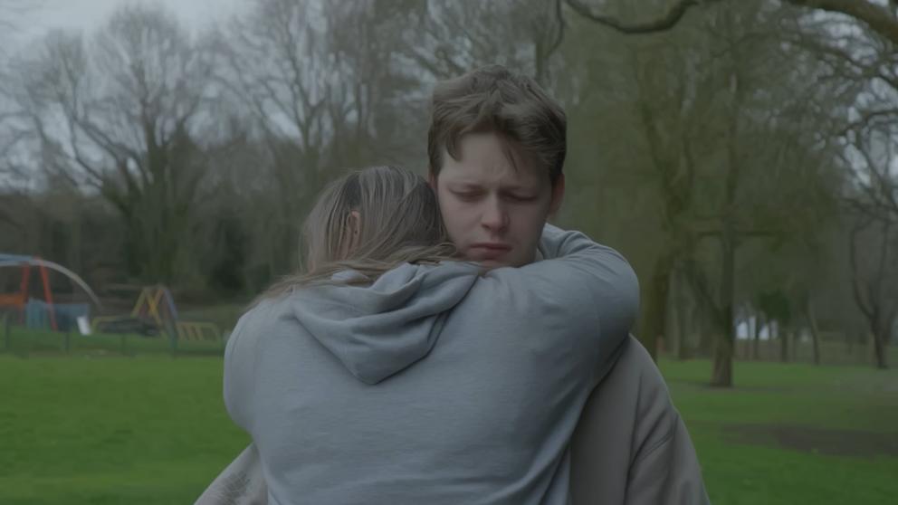 A man and woman hug in a park