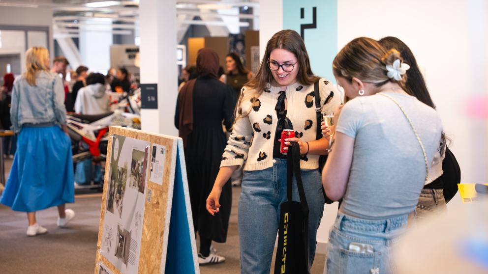 Visitors look at the work in interior design at the Degree Show